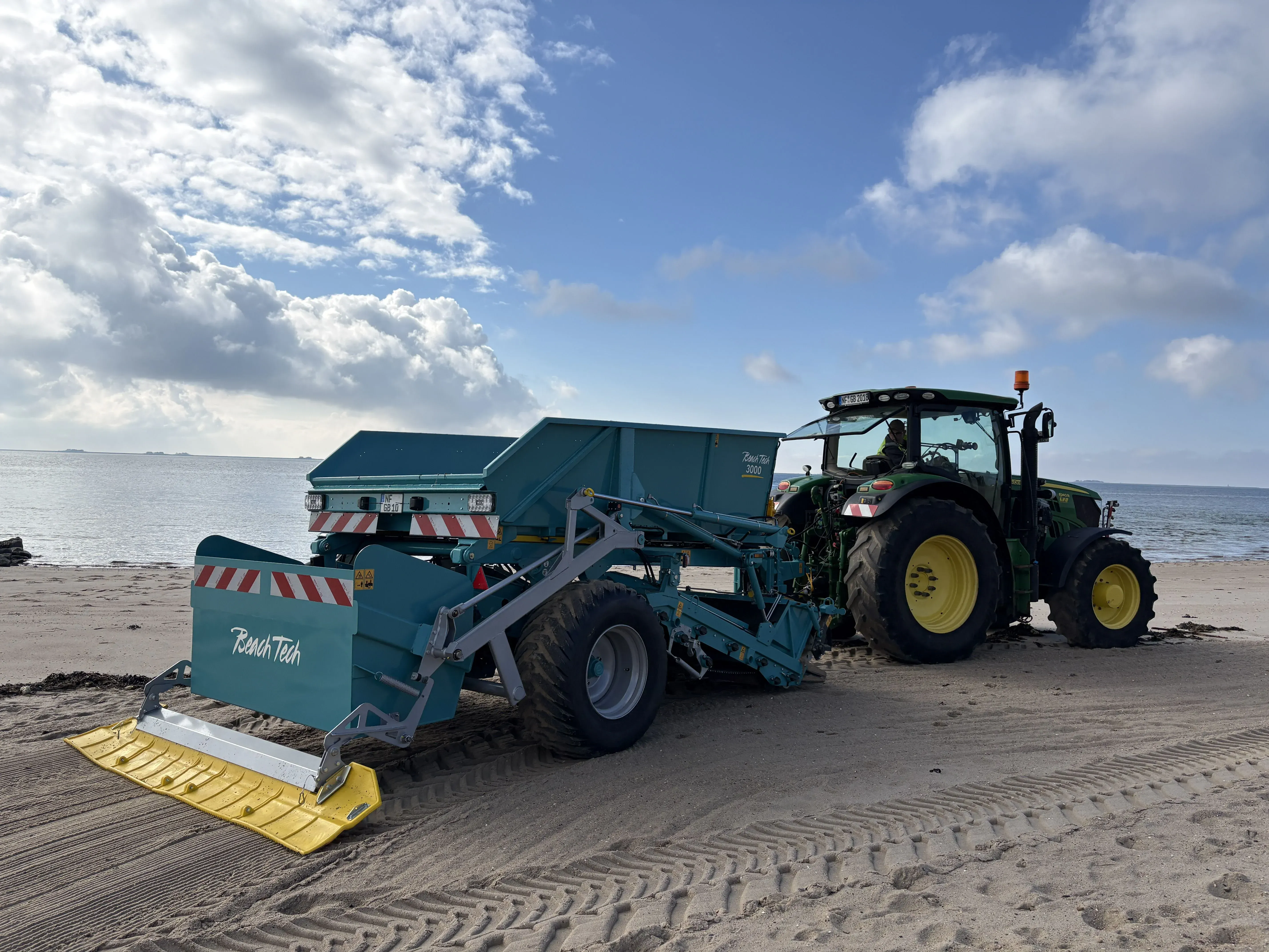 Limpiaplayas arrastrado BeachTech 3000 con tractor Vista lateral en la playa 