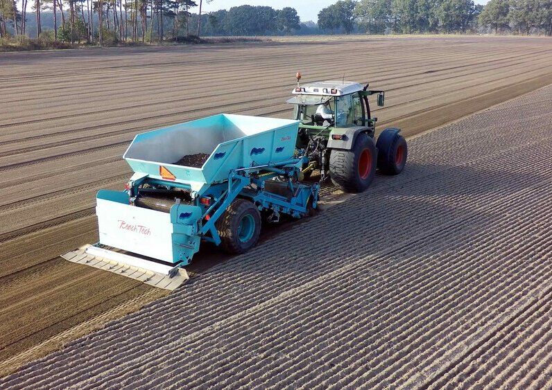 The BeachTech 3000 towed sand cleaner preparing an area for sod production