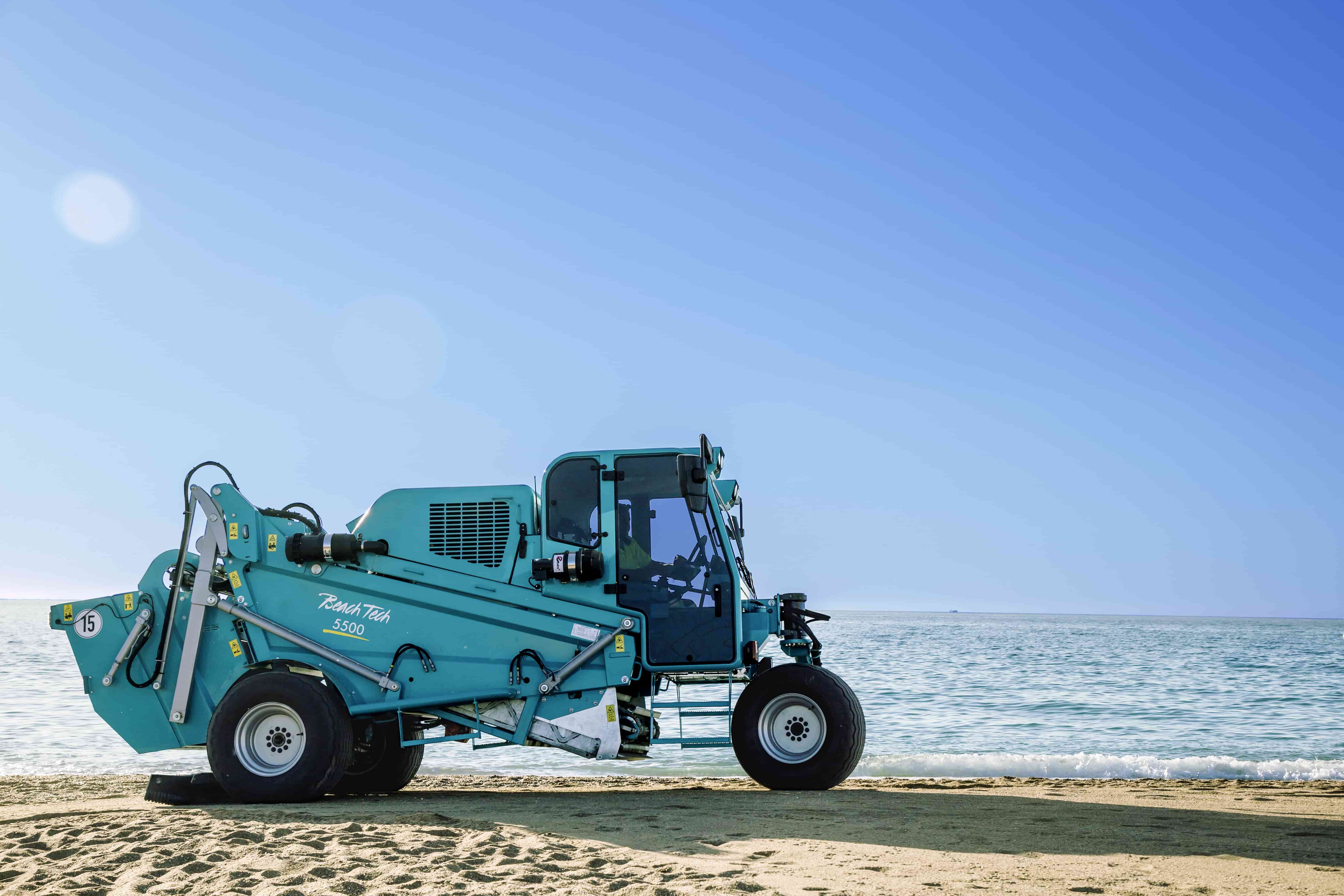 The BeachTech 5500 beach cleaning machine with its three-wheel-design cleaning a beach.
