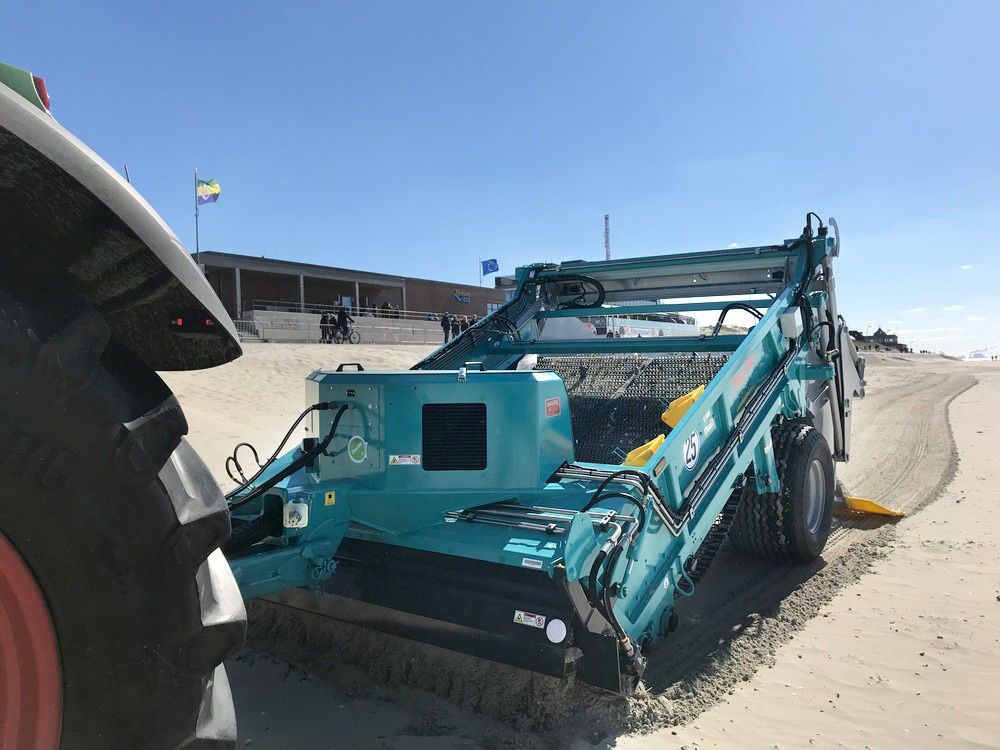 A tractor-towed beach cleaning machine