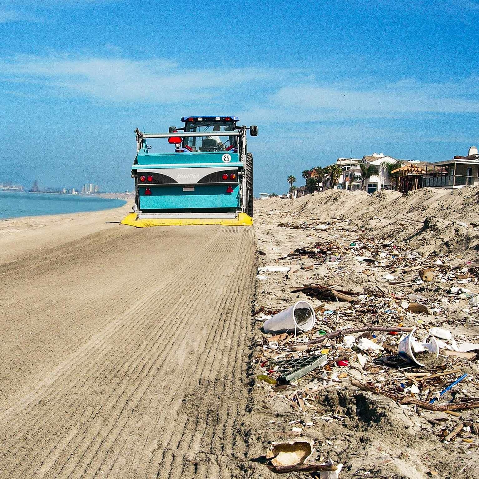 A BeachTech vehicle cleans a beach filled with trash