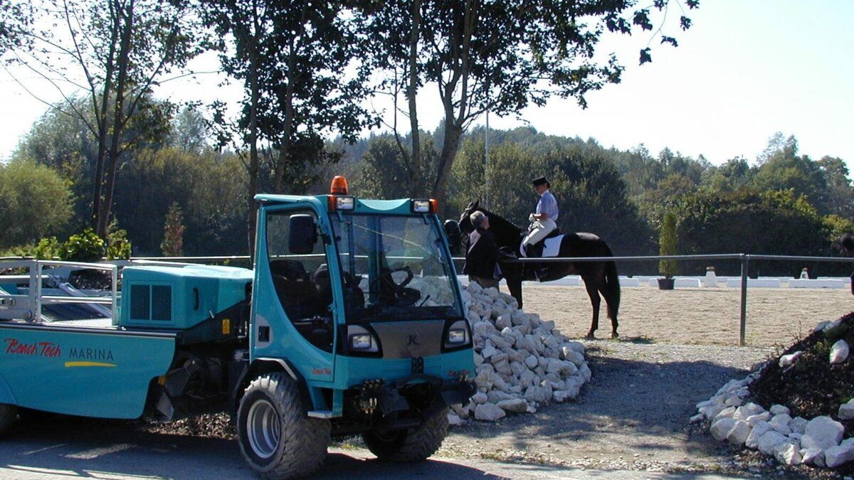Selbstfahrender BeachTech Reiniger im Einsatz auf einer weitläufigen Reitanlage neben Pferden.