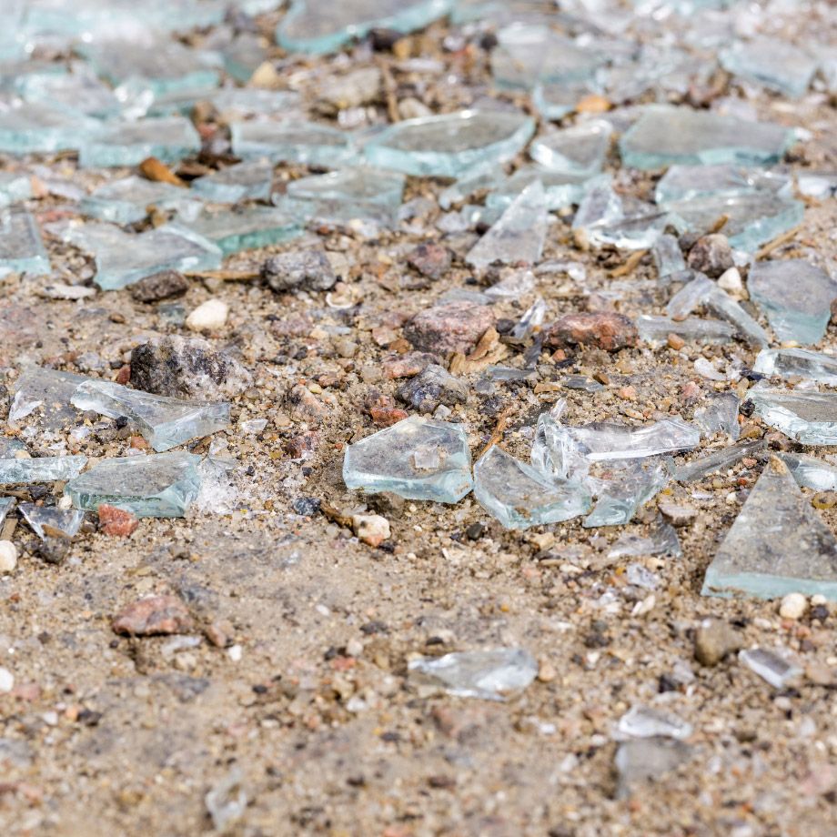 Glasscherben im Sand, die bei der Reinigung entfernt wurden.