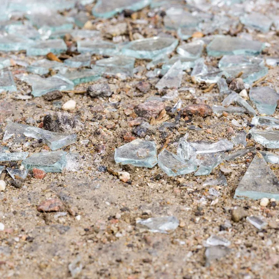 Glasscherben im Sand, die bei der Reinigung entfernt wurden.