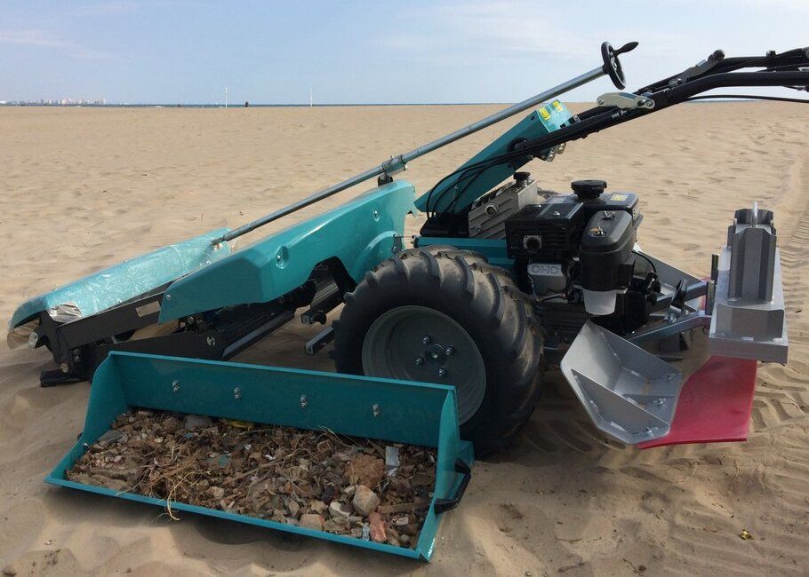 Contenitore di raccolta riempito davanti a un BeachTech Sweepy sulla spiaggia