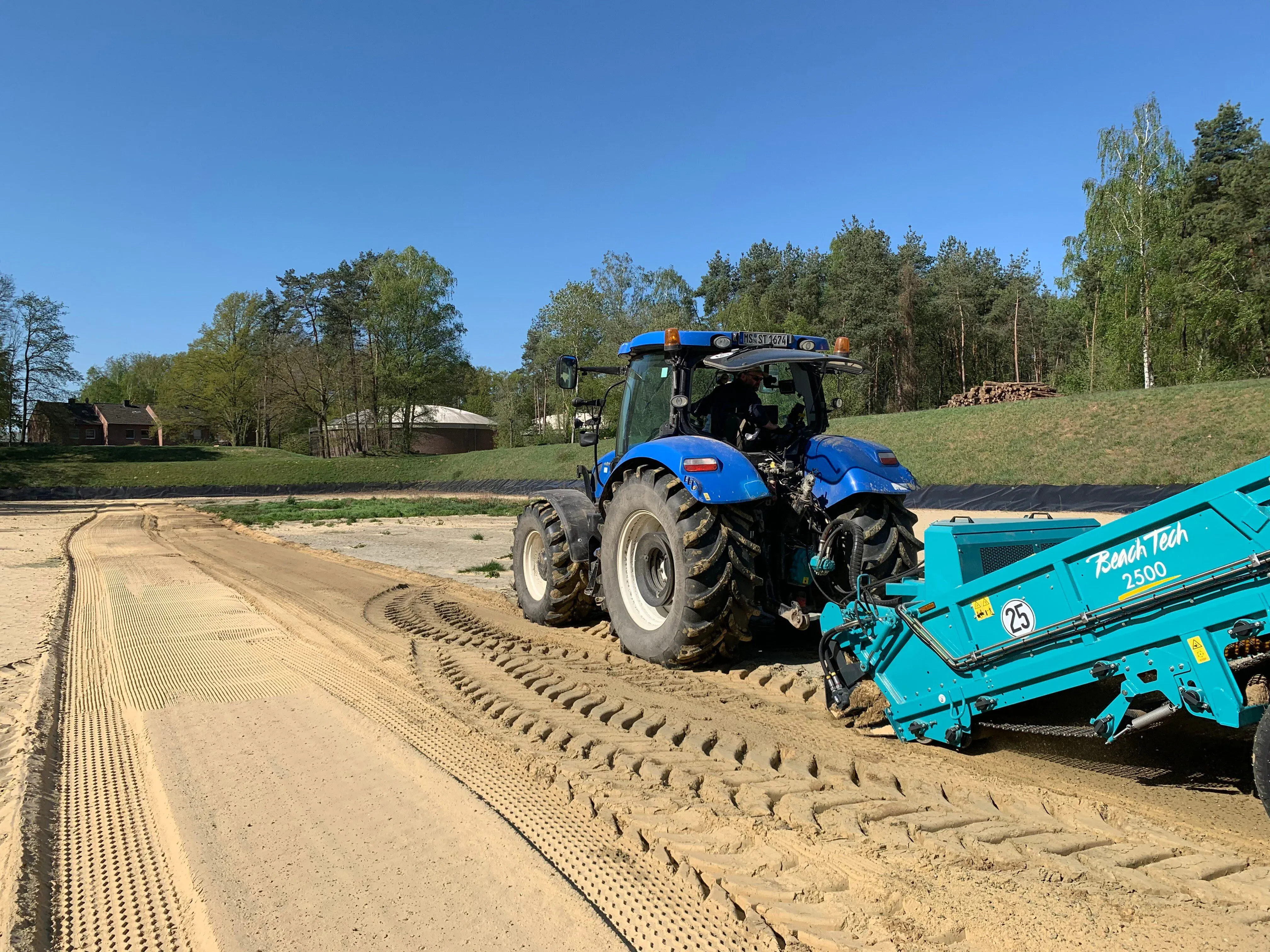 BeachTech 2500 Sandreinigungsmaschine im Einsatz auf sandigem Untergrund im Wasserfilterbecken.