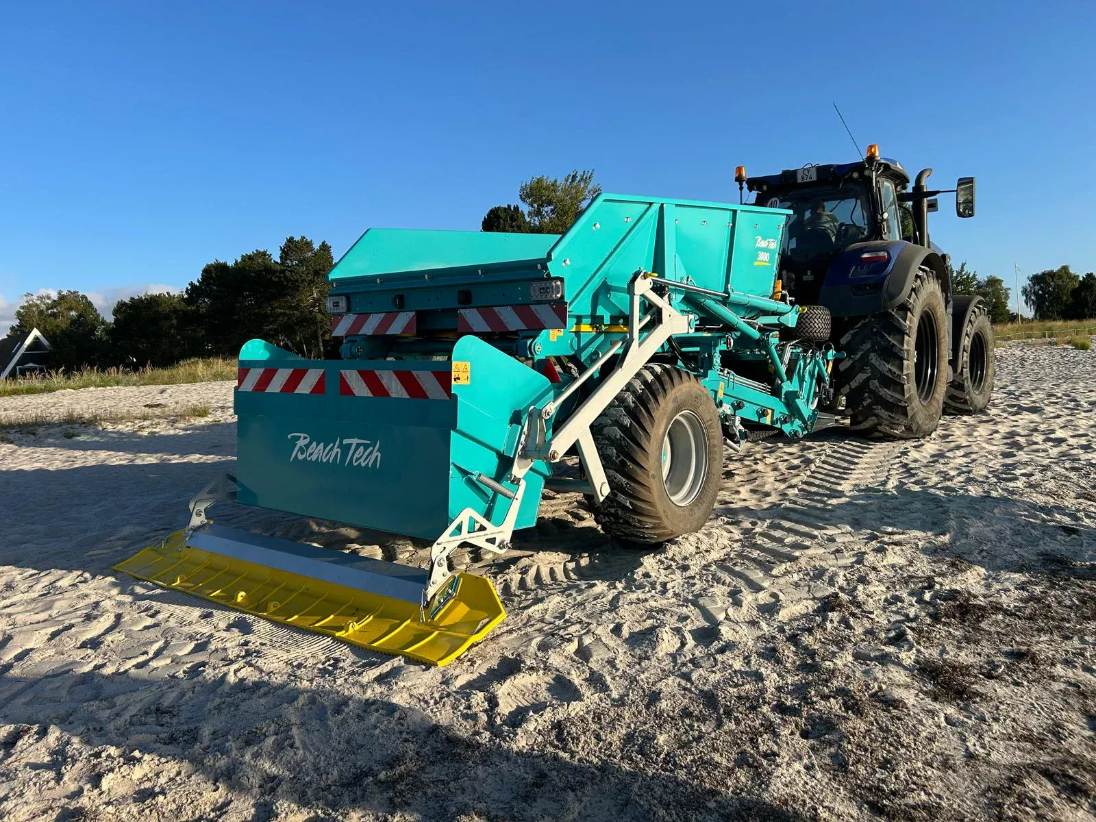 Gezogener Strandreiniger BeachTech 3000 mit Traktor Seitenansicht am Strand