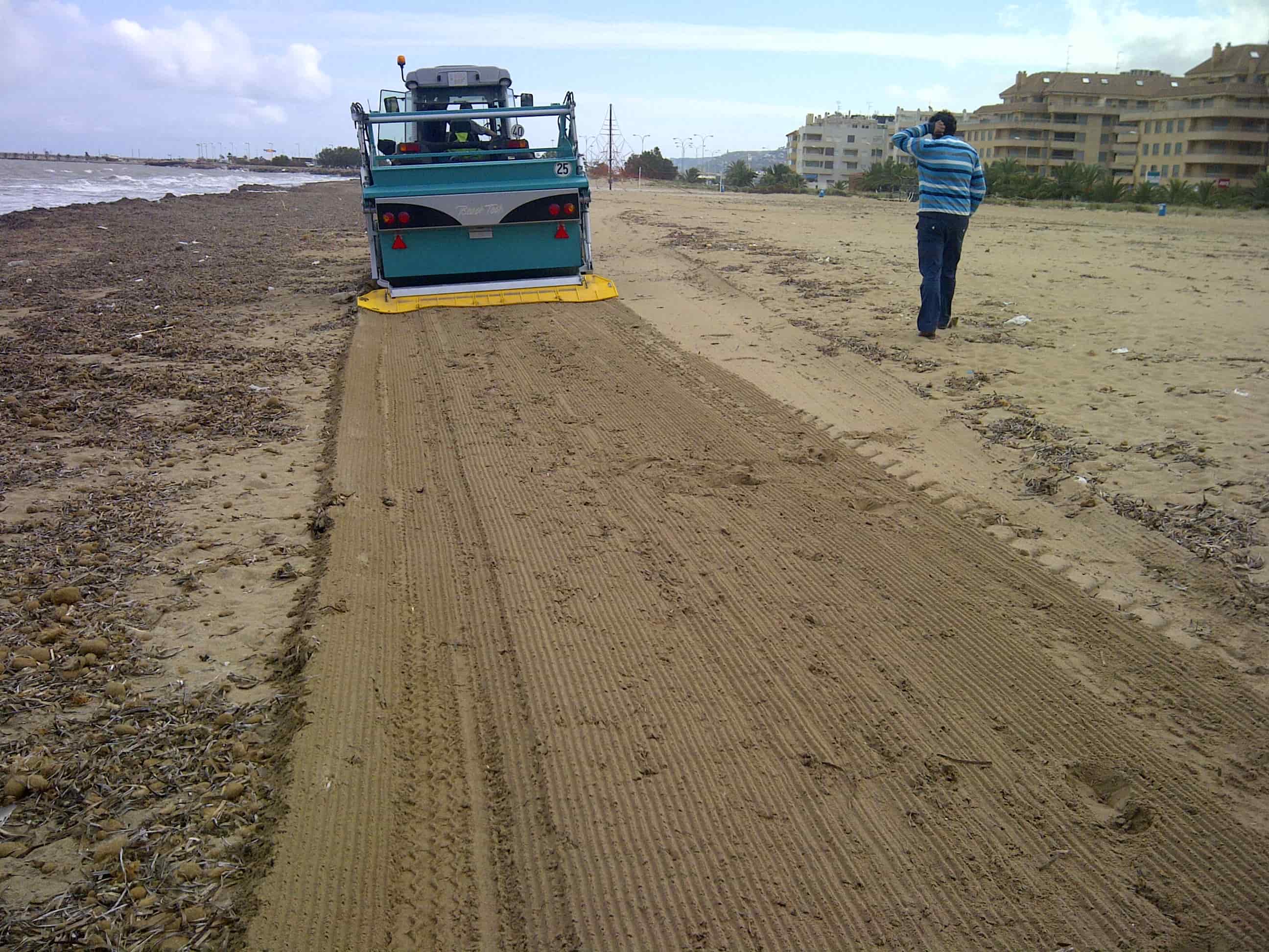 Vista posteriore di una macchina BeachTech che rimuove alghe spiaggiate su una spiaggia urbana.