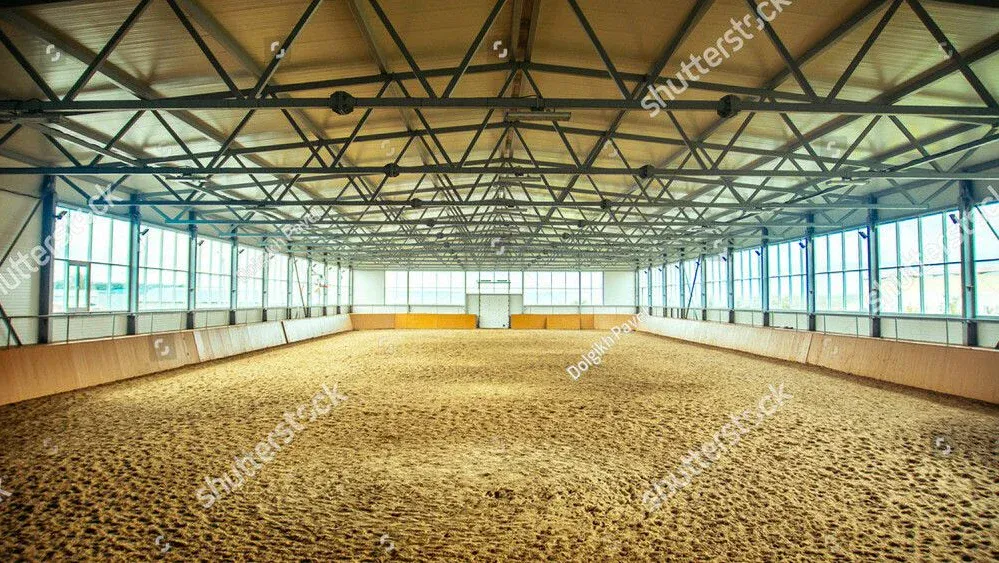 Saubere Reithalle mit gepflegtem Sandboden nach der Reinigung.
