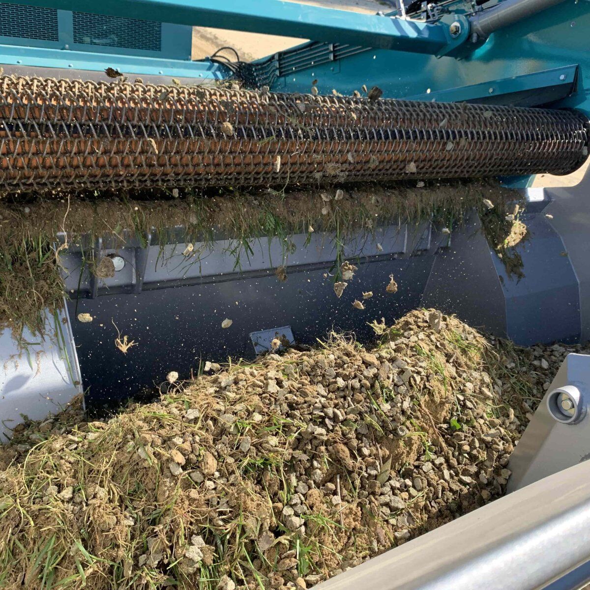 Nahaufnahme einer BeachTech Maschine, die Unkraut und Wurzelreste aus dem Boden entfernt.